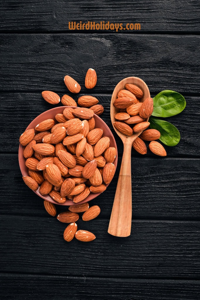 almonds in a bowl and on a spoon on a black background