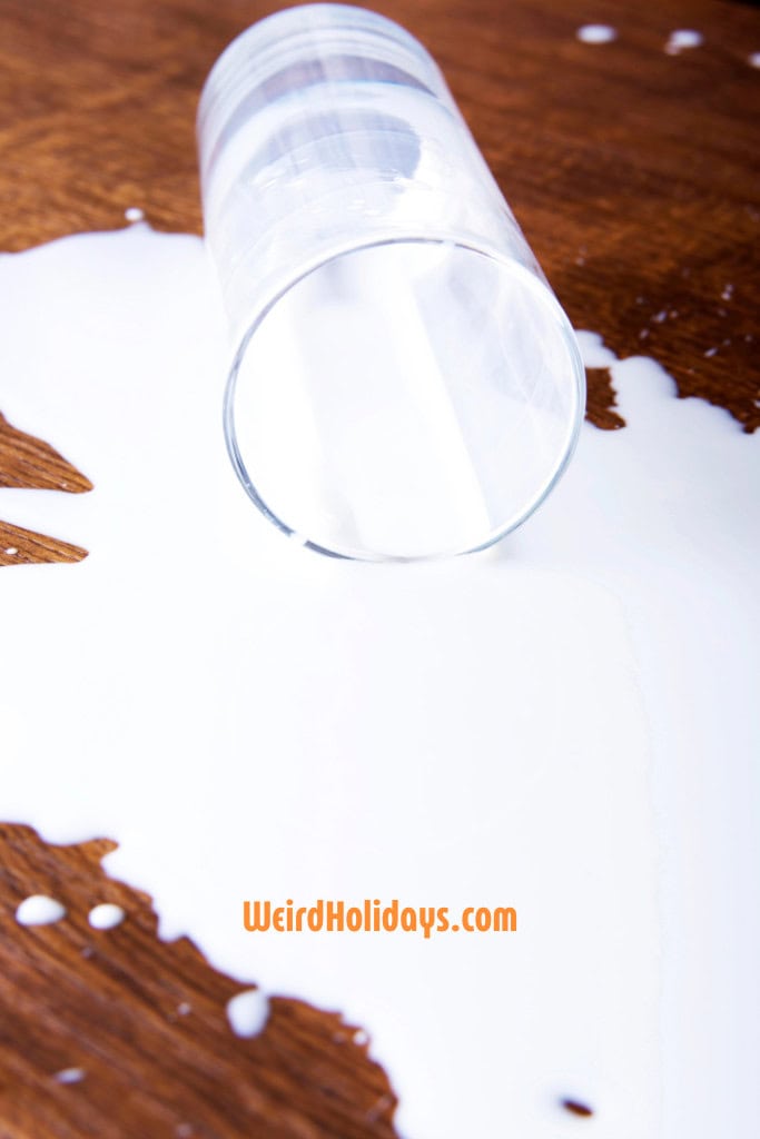 glass of milk knocked over on the table