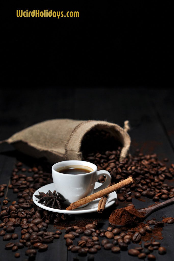 cup of coffee next to a bag of spilled coffee beans