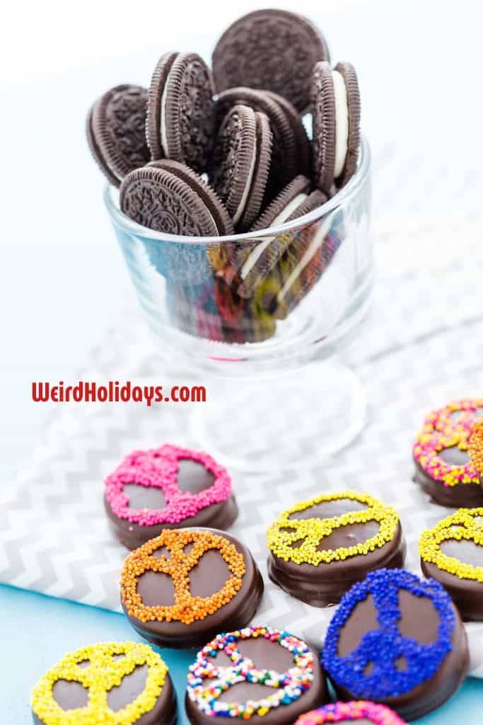 a glass of oreos and some decorated oreos on the table