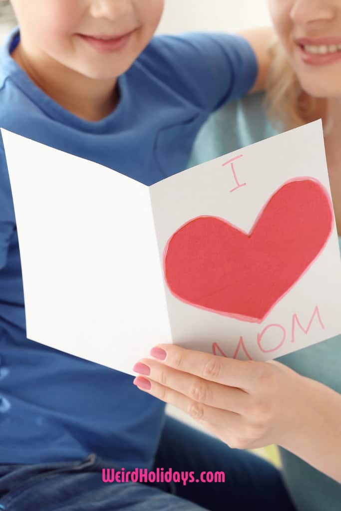 little boy giving his mom a card