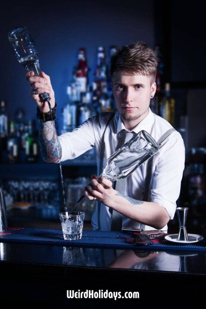 male mixologist pouring drinks in a bar